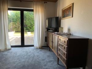 a room with a dresser with a tv and a dresser with a dress at Eifeloase Sophia in Nettersheim