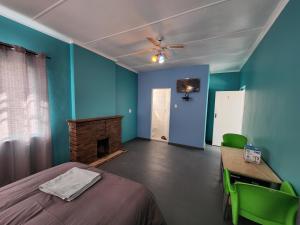 a bedroom with blue walls and a bed and a fireplace at Hasate Guest House ,4 st james street Oakdale Belliville Cape Town South Africa in Cape Town
