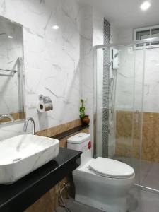 La salle de bains est pourvue d'un lavabo, de toilettes et d'une douche. dans l'établissement Triple J Hometel, à Bang Tao Beach