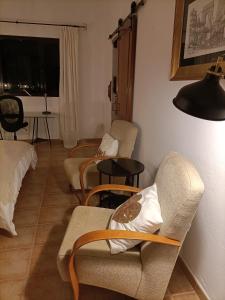 una sala de estar con sillas, mesas y una lámpara. en Casa El Cerco en Tabayesco
