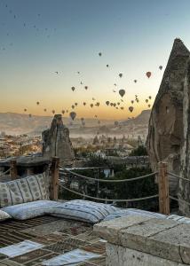 a bunch of hot air balloons flying in the sky at Anatolian Houses Cave Hotel & SPA in Göreme