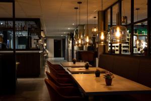 un restaurant avec des tables et des chaises ainsi qu'un bar dans l'établissement Hotel de Kastanjefabriek, à Eibergen