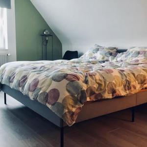 a bed with a colorful comforter on top of it at Alfie’s home in Malmedy