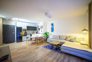 a living room and kitchen with a couch and a table at Apartamenty Via Marina in Wrocław