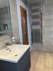 een badkamer met een witte wastafel en een douche bij Kings Apartment, 83 Kings Road in Harrogate