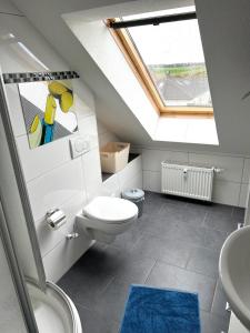 a bathroom with a toilet and a sink and a skylight at Ferien-Whg Bellevue nahe Steinhuder Meer mit Stellplatz in Hagenburg