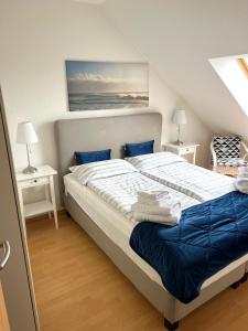 ein Schlafzimmer mit einem großen Bett mit blauer Bettwäsche in der Unterkunft Ferien-Whg Bellevue nähe Steinhuder Meer in Hagenburg
