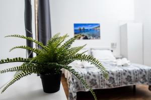 una maceta sentada en una mesa junto a una cama en B&B Lo Scrigno, en Vietri