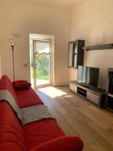 ein Wohnzimmer mit einem roten Sofa und einem TV in der Unterkunft La Lanterna sul mare in Livorno