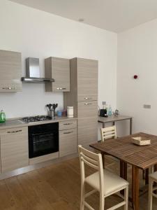 cocina con mesa de madera y comedor en La Lanterna sul mare en Livorno