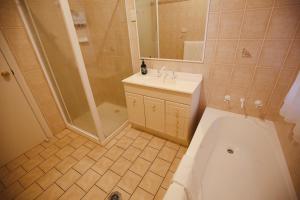 a bathroom with a shower and a sink and a toilet at Wagga Showground Villas in Wagga Wagga +31 photos