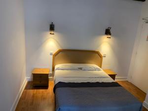 a bedroom with a bed with two lights on the wall at Hôtel Léonard de Vinci II in Paris