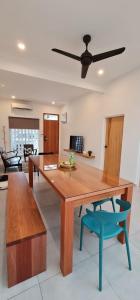 una sala da pranzo con tavolo in legno e sedia blu di Guesthouse @ Ipoh garden II a Ipoh