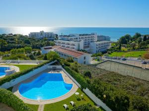 an aerial view of a swimming pool and the ocean at Apartamentos do Atlantico in Albufeira