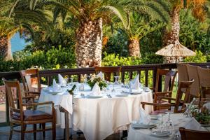 una mesa de comedor con manteles y servilletas blancos en Hersonissos Maris, en Hersonissos