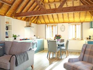 a living room with a couch and a table at The Barn At Banks Cottage in Pulborough