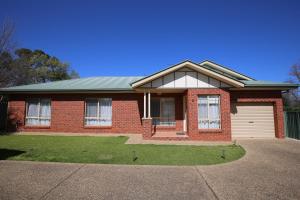 a red brick house with a white garage at Wagga Showground Villas in Wagga Wagga