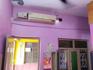 a purple wall with doors and a heater on it at TEMPLE VIEW GUEST HOUSE in Hampi