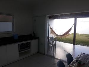 a kitchen with a sliding glass door leading to a patio at Praia do Sonho in Palhoça