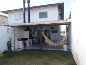 a white house with a yellow hammock on the porch at Praia do Sonho in Palhoça