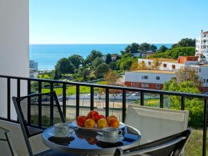 a plate of fruit on a table on a balcony at Apartamentos do Atlantico in Albufeira