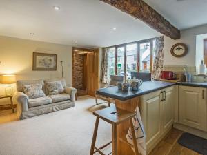 a kitchen and living room with a couch and a table at Castle House Cottage in Kirkby Stephen