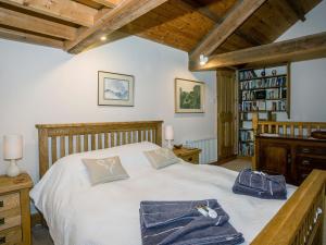 Un dormitorio con una cama grande en una habitación con techos de madera. en Castle House Cottage, en Kirkby Stephen