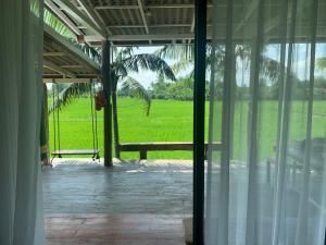 an open door to a porch with a palm tree at บ้านวิวนา Baan View Na in Ban Mae Cho