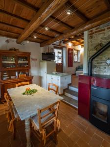 a kitchen and dining room with a table and a stove at Deliziosa Casetta Sull'Appennino Toscano in Montefegatesi