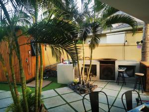 a patio with two palm trees and a fireplace at Casa del Dodo Villa de luxe avec piscine in Rivière Noire