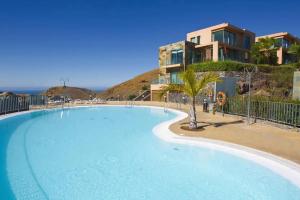 una gran piscina azul junto a un edificio en Holiday Home Villa Gema, spacious, scenic, Wlan ,AC en Maspalomas