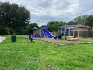 a playground with a slide in a yard at Newly Built Stylish Retreat with Designer Kitchen - Near Park & Beach in Corpus Christi