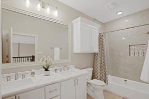 a white bathroom with a toilet and a sink at Newly Built Stylish Retreat with Designer Kitchen - Near Park & Beach in Corpus Christi +17 photos