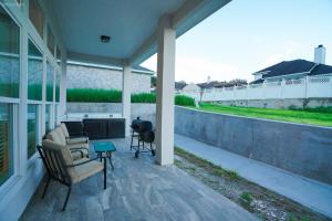 a porch with two chairs and a grill at Newly Built Stylish Retreat with Designer Kitchen - Near Park & Beach in Corpus Christi