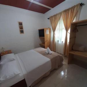 1 dormitorio con cama blanca y ventana en Nirvana House Calima Darien, en Calima