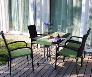 オストゼーバート・ディアーハーゲンにあるSTRANDFLIEDER App Nr 05 max 3 Persのポーチにテーブルと椅子4脚