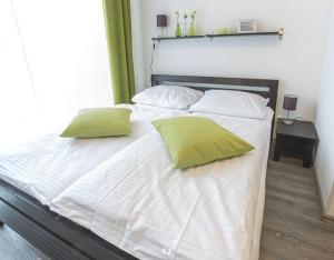オストゼーバート・ディアーハーゲンにあるSTRANDFLIEDER App Nr 05 max 3 Persの白いベッド(緑の枕2つ付)