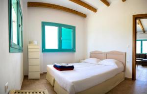 a bedroom with a bed and two windows at Saint George Villas & Apartments in Skiathos