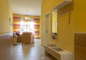 ein Wohnzimmer mit gelben Wänden und einem Sofa in der Unterkunft SONNENSEGEL App Nr 04 max 3 Pers in Dierhagen