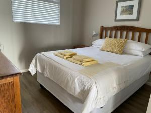 a bedroom with a bed with towels on it at 9 Coogee Bay in East London
