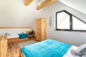 Schlafzimmer mit einem Bett und einem Fenster in der Unterkunft DOMKI TU I TERAZ in Szczawnica