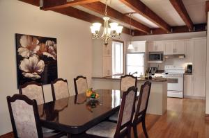 a dining room and kitchen with a table and chairs at Chalet Rouge in New Richmond