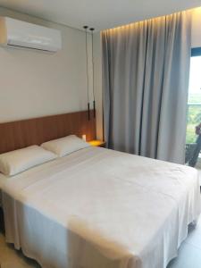 een slaapkamer met een groot wit bed en een raam bij Apartamento Salinas Premium Resort in Salinópolis +8 foto's