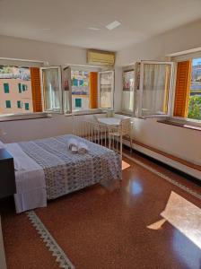a bedroom with a bed and a table and windows at Albergo Caffaro in Genova