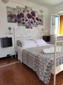 a bedroom with a white bed with purple flowers on the wall at Albergo Caffaro in Genova