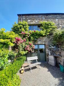 Un banco sentado frente a un edificio con flores. en Au Bout du Village, en Stoumont 7 fotos más