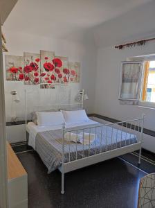 una camera da letto con un letto bianco e fiori rossi sul muro di Albergo Caffaro a Genova