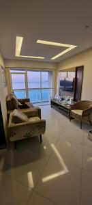 a large living room with a couch and a television at Cobertura Duplex Vista Mar in Mangaratiba