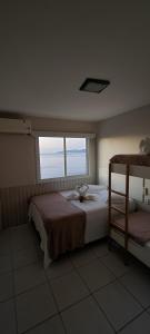 Schlafzimmer mit einem Bett und einem Fenster in der Unterkunft Cobertura Duplex Vista Mar in Mangaratiba