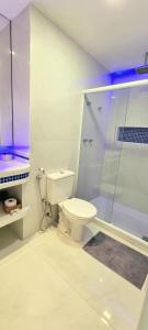 a white bathroom with a toilet and a shower at Cobertura Duplex Vista Mar in Mangaratiba